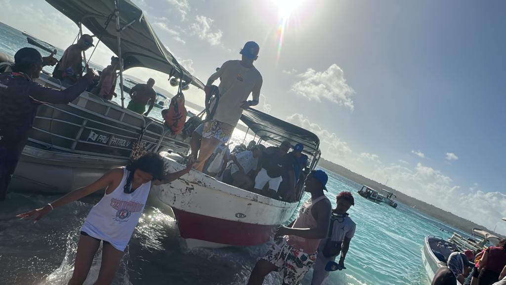 Viajeros bajando de la lancha en aguas turquesa durante la excursión a San Andrés, 2023