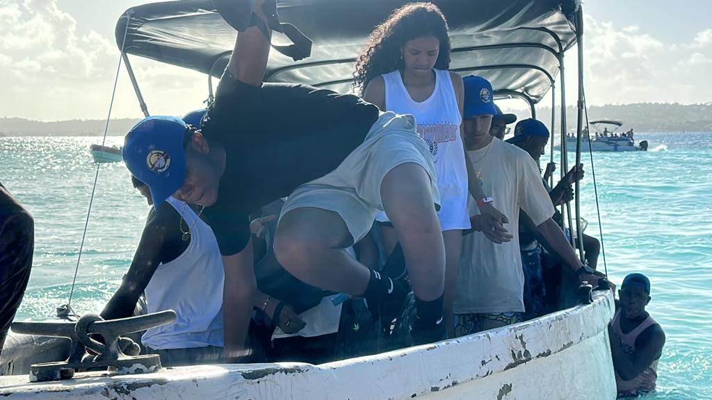 Grupo de jóvenes a bordo de una lancha sobre el mar turquesa de San Andrés, 2023