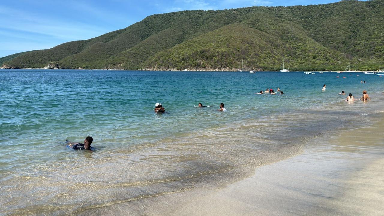Playa de aguas turquesa rodeada de montañas en Santa Marta, 2025
