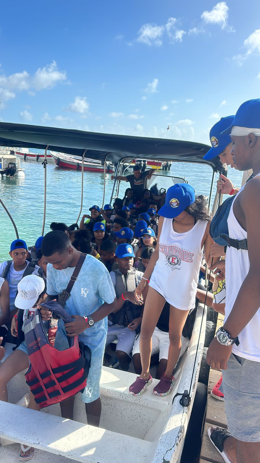 Estudiantes con gorras azules abordando una lancha en el muelle de San Andrés, 2023