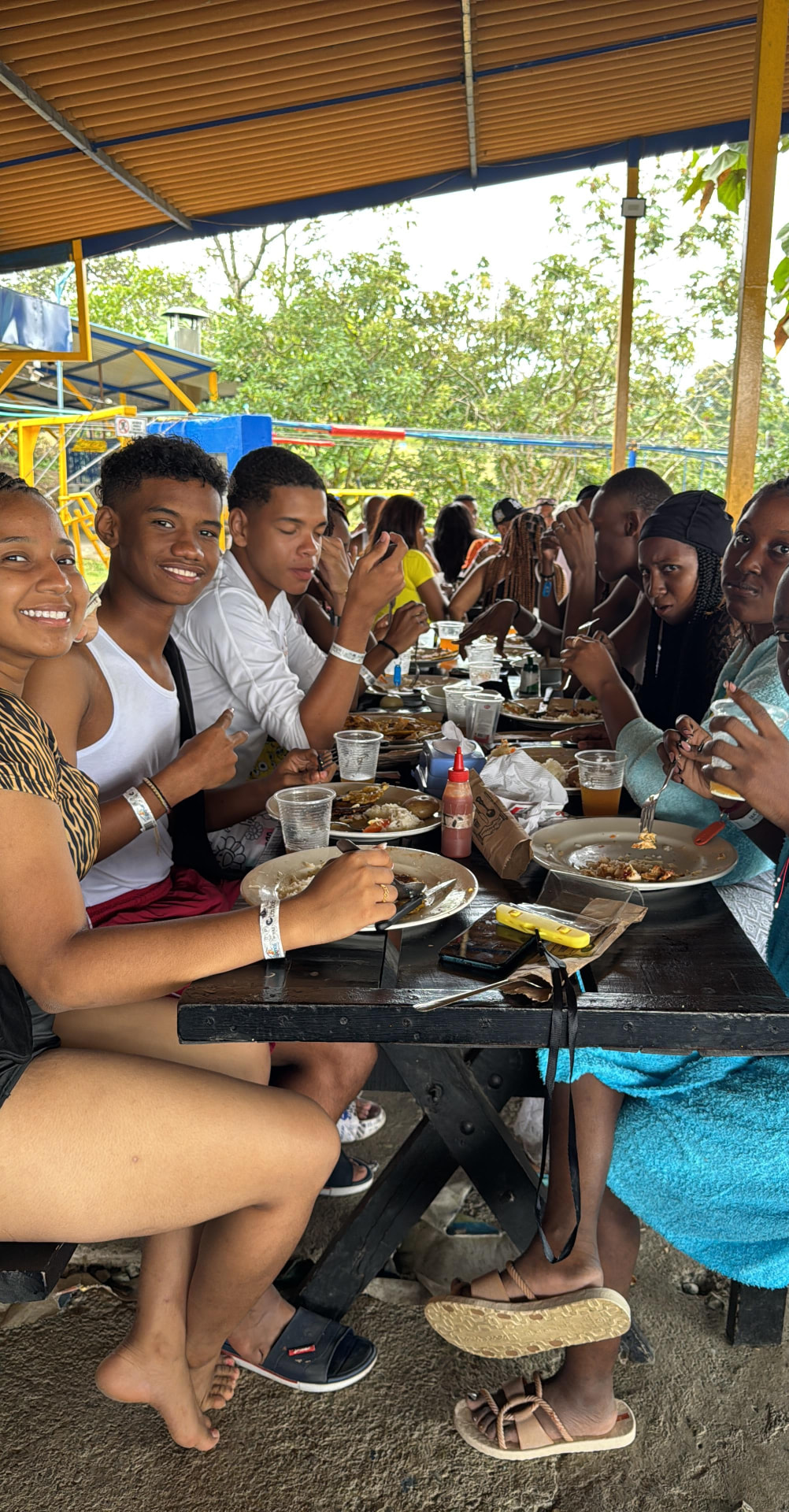 Jóvenes almorzando en mesas largas durante el pasadía en Montenegro, Quindío, 2024